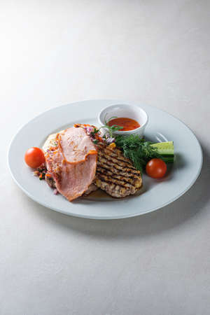 Menu for the restaurant: a plate with brisket, pork, chicken, vegetables and sauce.の写真素材