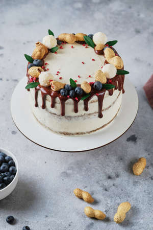 Honey sponge cake with salted caramel and peanuts. Cake with cream cheese cream and peanut butter. Delicious natural and beautiful festive dessert.の写真素材