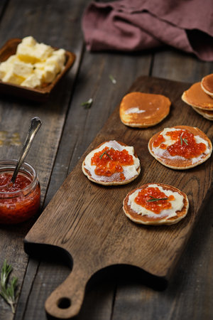 Pancakes with red caviar on a wooden table in a rustic style.の写真素材