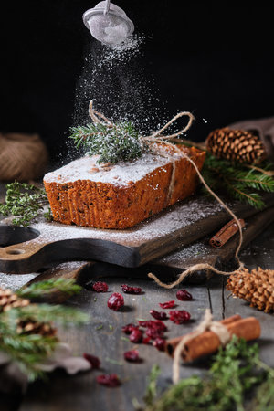 New Year's gingerbread cake with kumquat, dried berries and fruits. A festive dessert decorated with spruce twigs and fresh berries and fruits.の写真素材