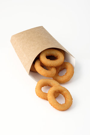 Fried onion rings in packaging on a white background.の写真素材
