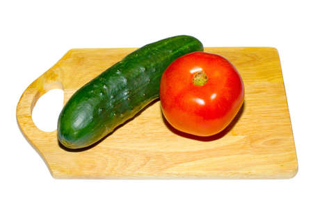 the red tomato and green cuke on boardの写真素材