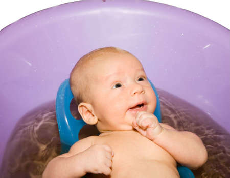 the bathing newborn boy in lilac bath