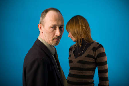 senior man and young woman on blue background