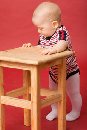 the small boy standing near wood stoolの写真素材