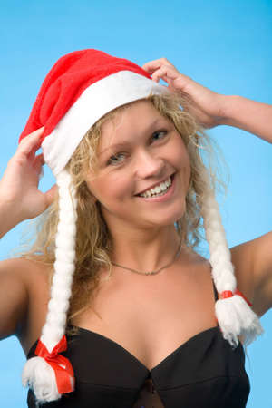 young blond woman in red christmas capの写真素材