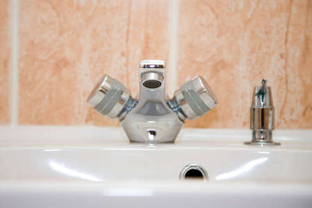 a closeup of the chrome tap in a bathroomの写真素材