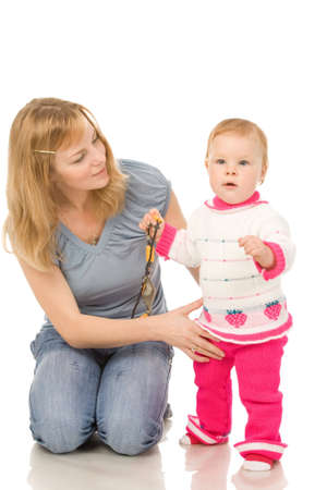 portrait of the mother with young daughter making first steps isolated on a white backgroundの写真素材