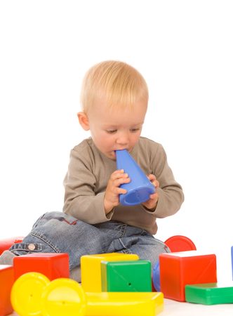 little boy play with bricks. isolated on a white backgroundの写真素材