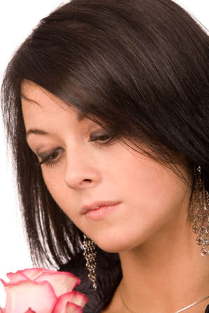 closeup portrait of the young brunette looking at pink roseの写真素材