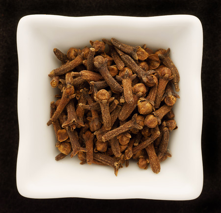 Spice cloves in a ceramic bowl. Isolated on black.の写真素材