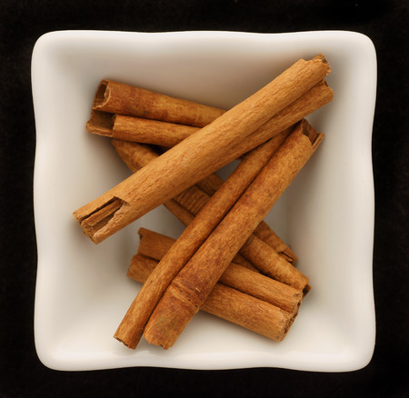 Spice cinnamon in a ceramic bowl. Isolated on black.の写真素材