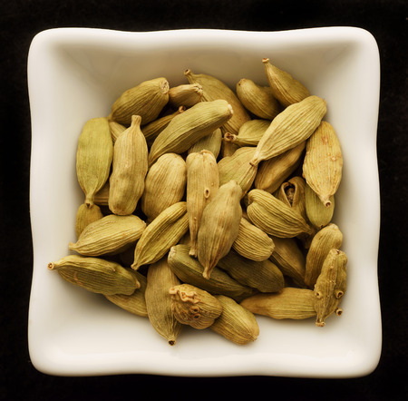 Spice cardamom in a ceramic bowl. Isolated on black.の写真素材