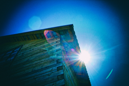 a ray of sunshine near a wooden house, Russiaの写真素材