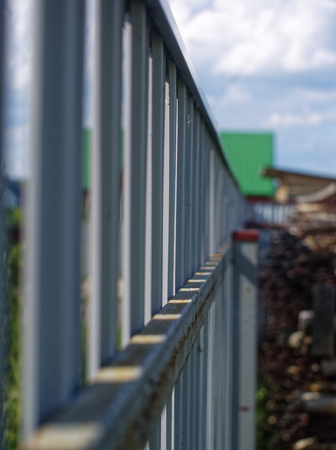 sunlight through a metal fence in summer, Russia