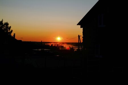 wooden rural house on the background of the sunset, Russiaの写真素材