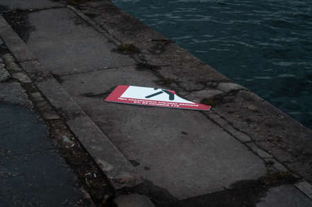 broken sign on the embankment in the springの写真素材