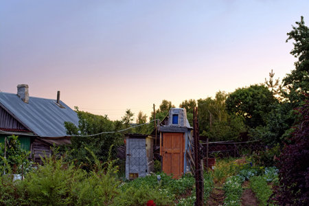 Rural house at sunset in summer, Russiaの写真素材