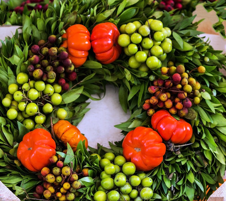 Mediterranean laurel wreath with green olives and red tomatoesの写真素材