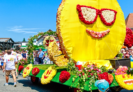 STEINFURTH, GERMANY-JULY 15, 2018 Enormous smiley on a parade carriage. Germany's "Rose Village" Steinfurth celebrates 150 years of rose cultivation with a large parade.のeditorial素材
