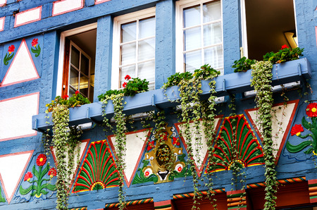 ALSFELD, GERMANY-AUGUST 18, 2018: Timber framed pale blue painted house with floral decoration and colored ornaments in historic city center.のeditorial素材