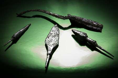 Ancient scissors and arrows on a brilliant green background in a beam of light
