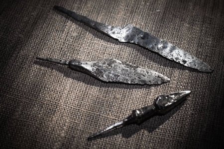 Medieval knife and two arrowheads are on the gray fabricの写真素材