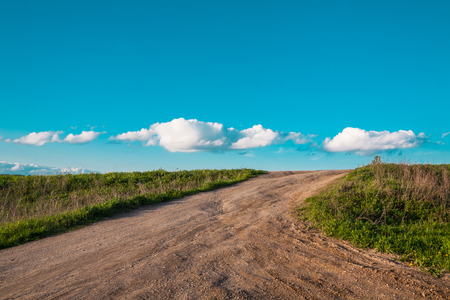 simple rural landscape with the unpaved road going directly to cloudsの写真素材
