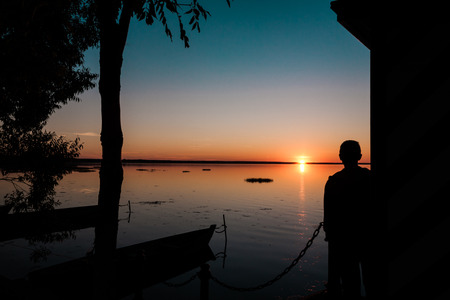 silhouette of the man looking at sunsetの写真素材