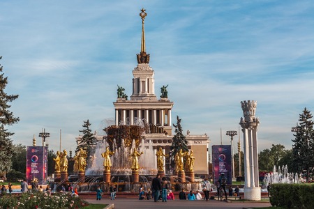 Moscow, Russia - October 5, 2015: The fountain of friendship of the people of the USSR against the building of the central entrance on an exhibition. In an image of fifteen girls fifteen republics of the USSR are stylized.のeditorial素材