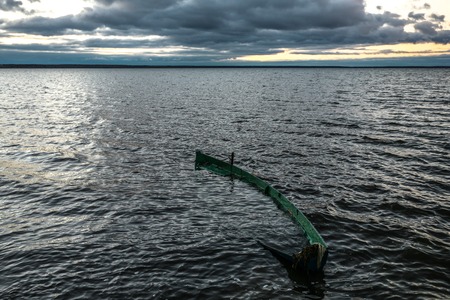 The boat flooded with waves and rains on an autumn declineの写真素材