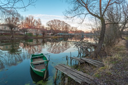 Pereslavl-Zalessky, Russia - November 07, 2015: The green boat on the parking at the river bank Trubezh late autumn evening.のeditorial素材