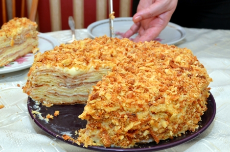Cutting the birthday cake. Fresh layer cake "Napoleon", with custard.の写真素材