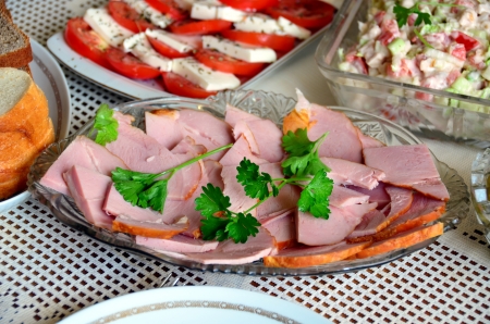 Serving the festive table, sliced ham on the plate.の写真素材