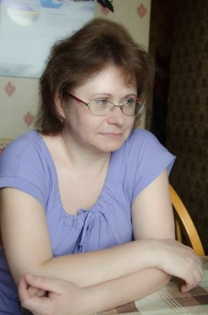 The woman - a housewife watching TV at the kitchen tableの写真素材