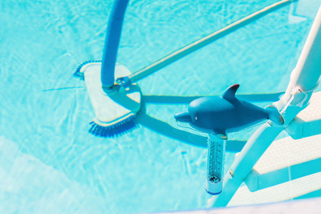 Thermometer and brush in the poolの写真素材