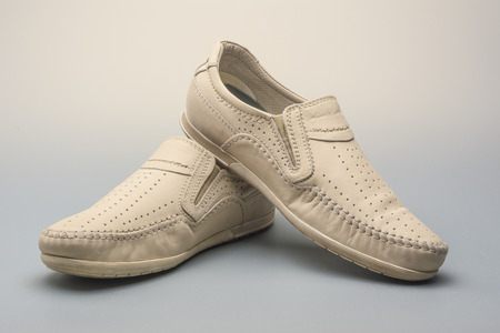 Sand summer men's moccasins on a gray background