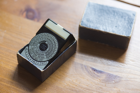 Optical exponometer retro and a dark blue box for it, on a brown table