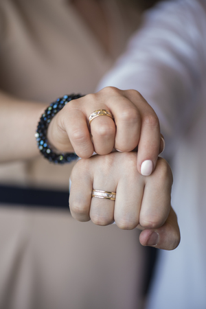 Hands of the bride and groom with engagement rings, clenched in fistsの写真素材