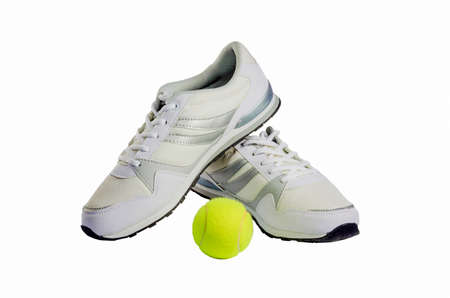 White men's sneakers and a tennis ball on a white backgroundの写真素材