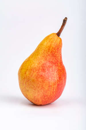 Red-yellow, bright pear on the table on a white backgroundの写真素材
