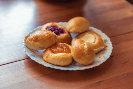 Homemade cakes on a brown kitchen table - pies, cheesecakes, croissantsの写真素材