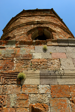 Stone wall of an ancient church covered with moss