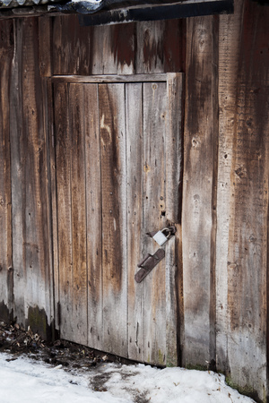 Wooden door of an old barn with a metal lockの写真素材