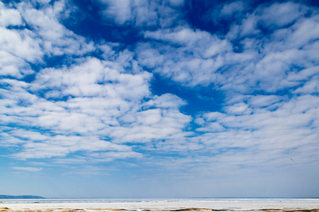 White clouds on a blue sky on a frozen riverの写真素材