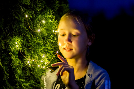 the girl holds the lights in the evening in the gardenの写真素材
