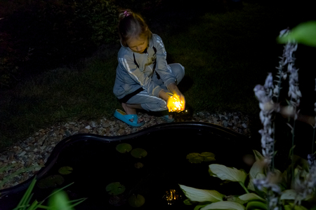 the girl holds the lights in the evening in the gardenの写真素材