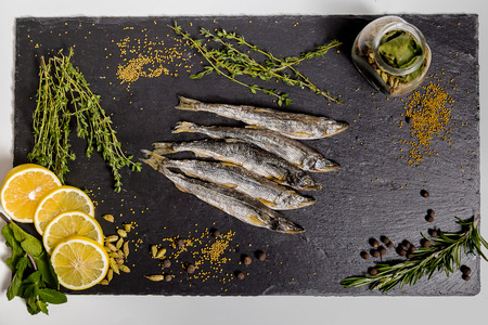 dried smelt lies on a black dishの写真素材