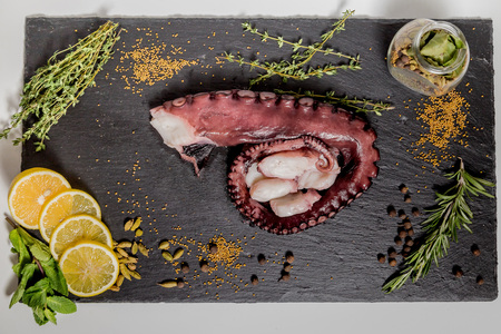 smoked octopus tentacles on a black dishの写真素材