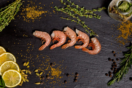shrimp langoustine lie on a black plateの写真素材